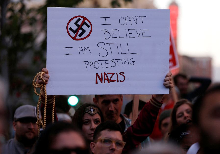 A demonstrator holds signs during a rally in response to the Charlottesville, Virginia